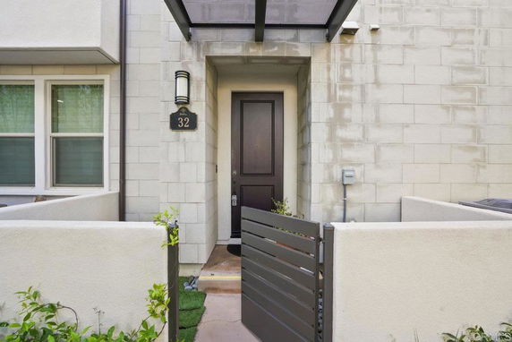 Front entrance view of a modern house with a dark door and light exterior walls.