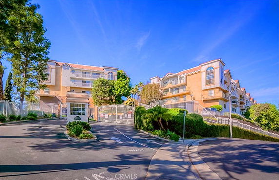 Front view of a multi-story residential building with gated entrance.