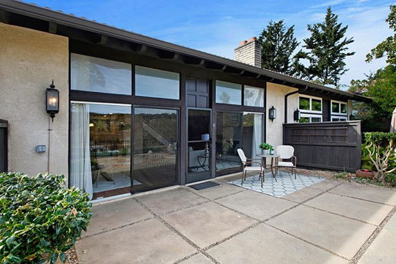 Front view of a house with large windows and a patio area.