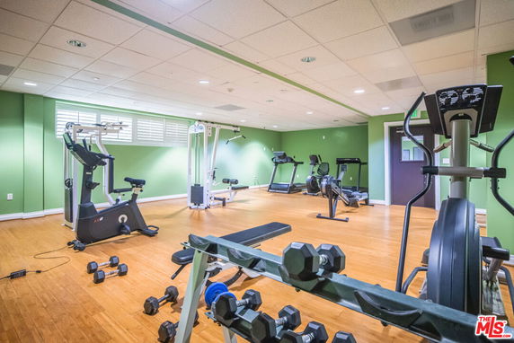 Indoor gym with exercise equipment including treadmills, stationary bikes, and weights.