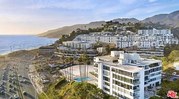 Panoramic view of coastal buildings overlooking a beach and ocean.