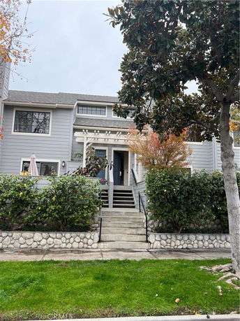 Front view of a two-story house with stone facade and steps leading to the entrance.