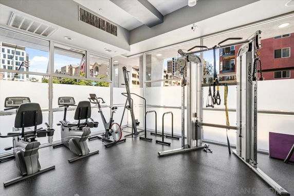 Indoor gym area with exercise equipment and large windows.