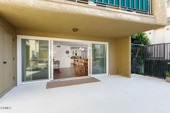 Front view of a house with a sliding glass door entrance to an outdoor patio area.