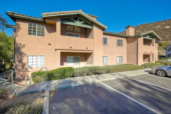 Front view of a two-story residential building with multiple windows and a beige exterior.