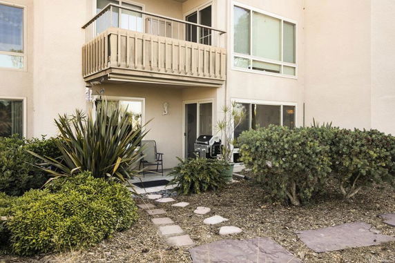 Front view of a house with a patio and balcony.