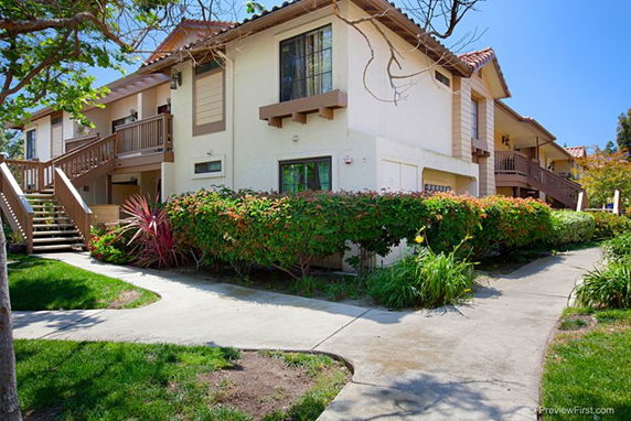 Front view of a two-story residential building with a balcony and walkway.