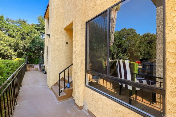 Exterior view of a building entrance with stucco walls and a window.