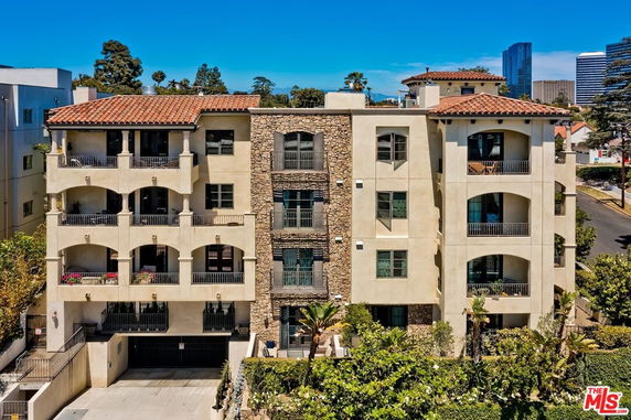 Front view of a multi-story residential building with balconies and stone accents.