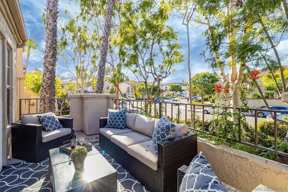 Outdoor seating area overlooking a suburban street surrounded by trees.