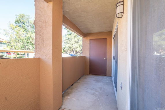 View of a covered outdoor walkway next to a building entrance.