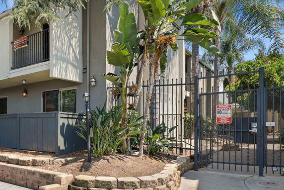 Front view of a two-story building with a gated entrance and balcony.