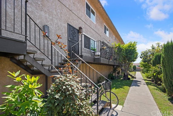 Front view of a two-story building with external staircases and a pathway.