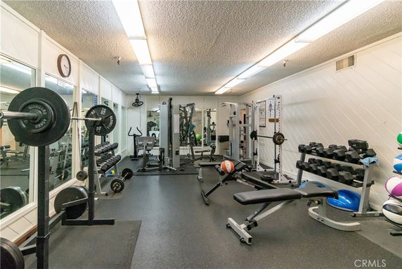 Indoor gym area with various exercise equipment and weights.