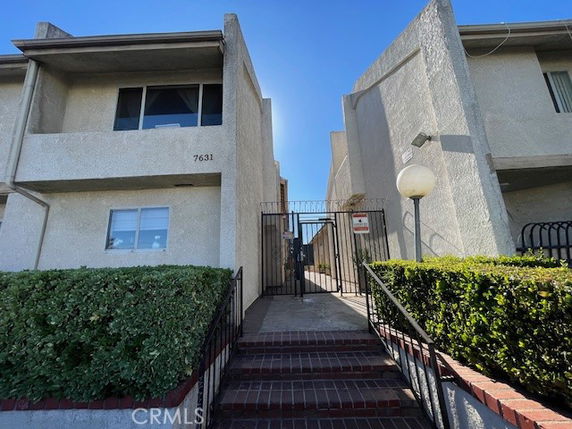 Front view of a multi-story residential building with a gated entrance.