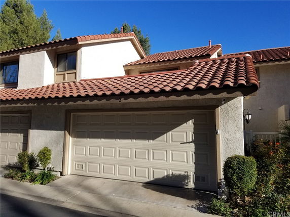 Front view of a house with a double garage and tiled roof.