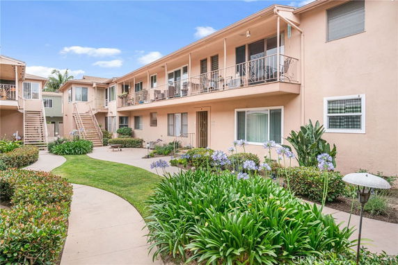 Front view of a multi-story apartment building with external staircases and balconies.