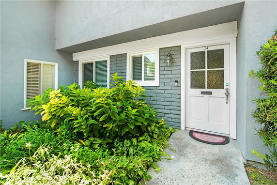 Front view of a house with a white door and small windows.