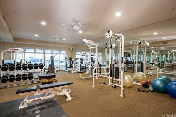 Interior view of a gym area with various fitness equipment including weights and exercise machines.