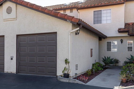 Front view of a two-story house with attached garage and tiled roof.