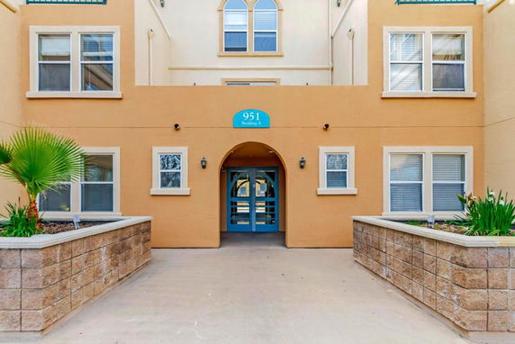 Front view of a multi-story building with arched entrance and multiple windows.