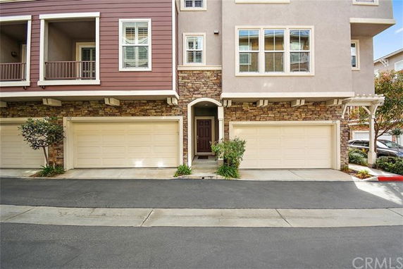 Front view of a multi-story residential building with a double garage.