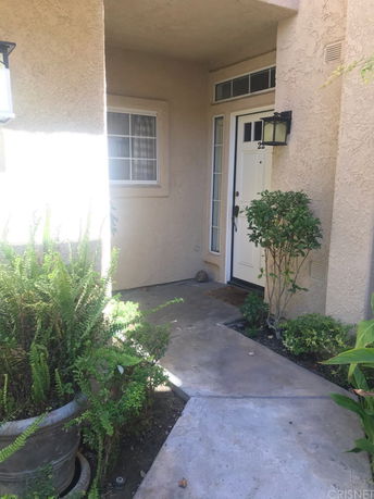 Entrance view of a house with a single door and outdoor lighting.