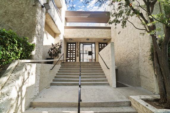 Entryway with steps leading to a gated entrance of a building.