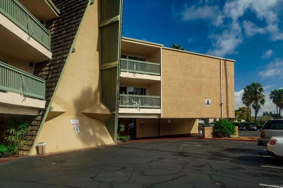 Front view of a mid-rise building with balconies and an angular facade.