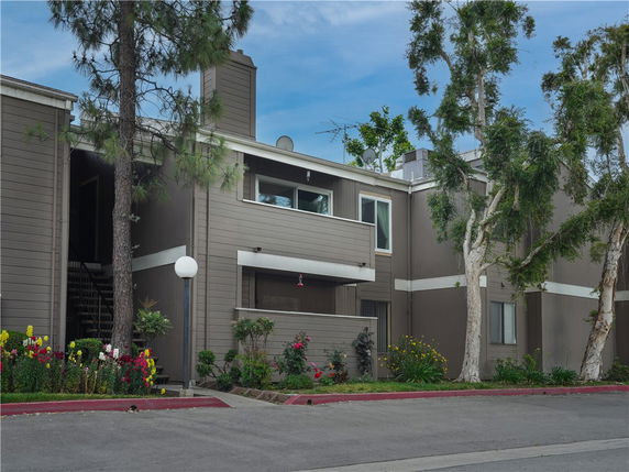 Front view of a two-story residential building with a chimney and balcony.