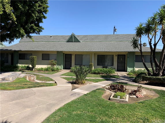 Front view of a single-story house with green trim and a gabled roof.