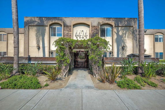 Front view of a multi-story building with a number 4424 above the entrance.