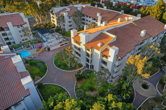 Aerial view of a residential complex with multiple buildings and a swimming pool.