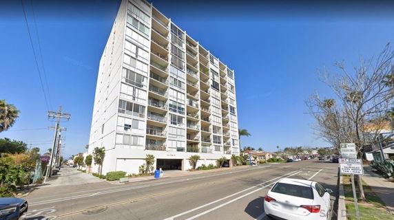Front view of a multi-story building with balconies.