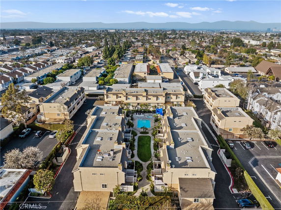 Panoramic view of multiple residential buildings surrounding a central swimming pool area.