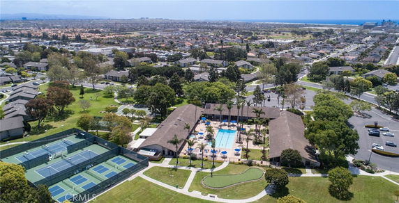 Panoramic view of a neighborhood with tennis courts and a community swimming pool.