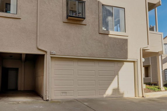 Front view of a house with a garage and upper-level windows.