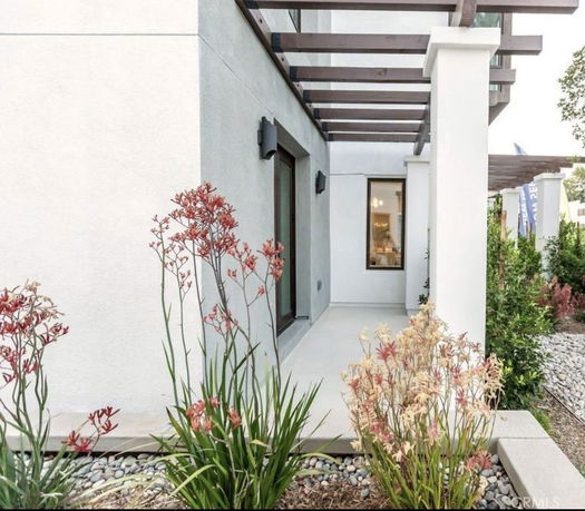Front view of a modern house with a patio and large windows.