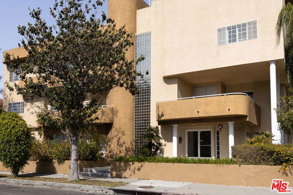 Front view of a multi-story building with balconies and glass block windows.