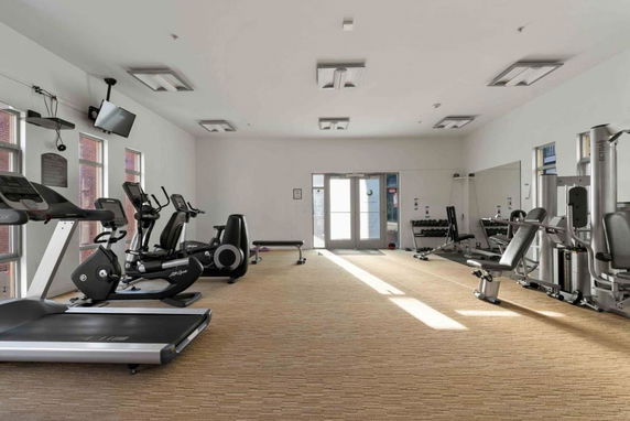 Interior view of a gym with various exercise equipment and machines.