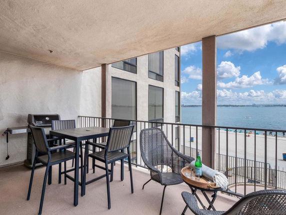 Balcony with outdoor seating and a view of the ocean.