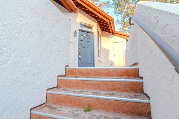 Staircase leading to the front entrance of a house with a blue door.