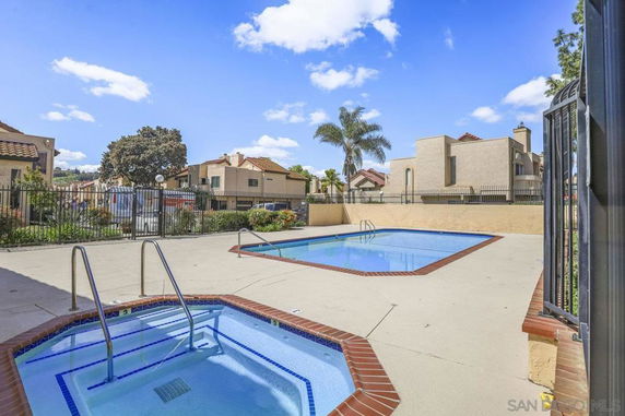 Outdoor swimming pool area with a jacuzzi.