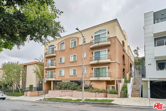 Front view of a multi-story apartment building with balconies.