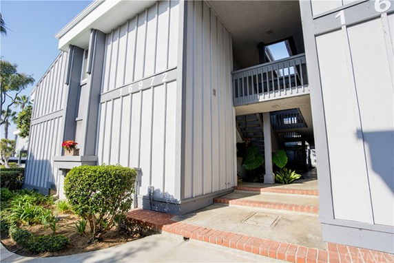 Front view of a multi-story building with exterior stairs and entryway.