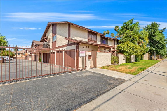 Front view of a multi-story residential building with gated entry.
