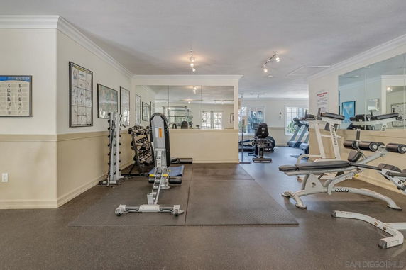 Interior view of a gym area with exercise equipment, including treadmills and weight machines.