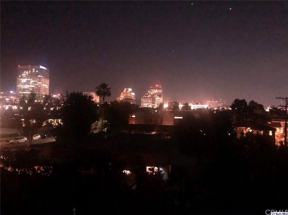 Nighttime view of a city skyline with illuminated buildings.