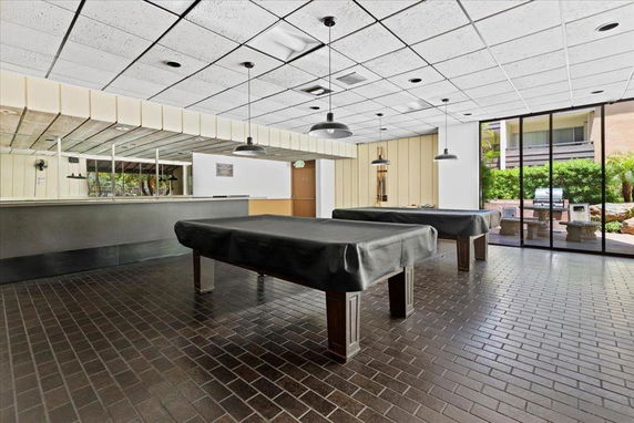 Indoor area with billiard tables and large windows.