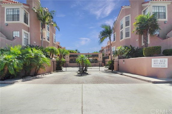 Front view of a residential complex with gated entrance and multiple stories.